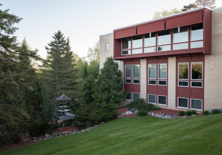 terracotta colored office building on a grassy hill